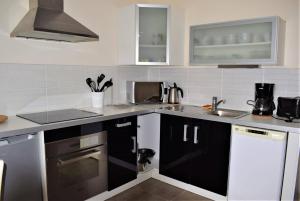 una cocina con armarios en blanco y negro y fregadero en Appartement 3 étoiles avec vue sur mer au 3ème et dernier étage à TREGASTEL - Réf 25, en Trégastel