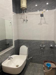 ein Badezimmer mit einem weißen Waschbecken und einem WC in der Unterkunft Hotel ashiyana stay in Lucknow