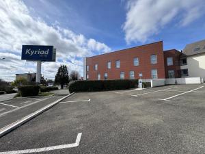 a sign in a parking lot in front of a building at Kyriad Le Mans Est in Le Mans