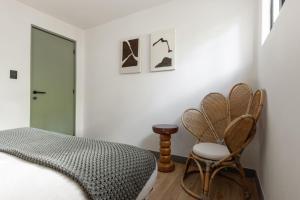 ein Schlafzimmer mit einem Bett und einem Stuhl in der Unterkunft Baranda OCHO in Mexiko-Stadt