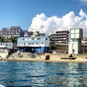 um edifício azul na margem da água em Guesthouse Geragera em Kobe