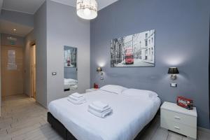 1 dormitorio con cama blanca y autobús rojo en Le Ghiande Guest House, en Casal Palocco