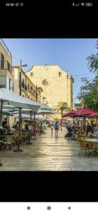 una strada con tavoli, sedie e ombrelloni di Apartamento Jordi a Cala Figuera