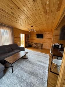 ein Wohnzimmer mit einem Sofa und einem Tisch in der Unterkunft WooD_House_Issyk-Kul in Bosteri