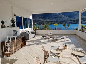 a patio with tables and chairs and a view of the ocean at Apartments Holidays Roko in Grebaštica