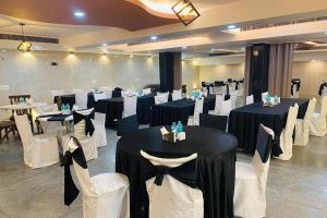 - une salle de banquet avec des tables et des chaises en noir et blanc dans l'établissement Hotel Vishal Residency, à New Delhi
