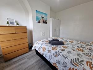 a bedroom with a bed and a dresser in it at Comfortable 2 bedrooms flat in Oval Central London in London
