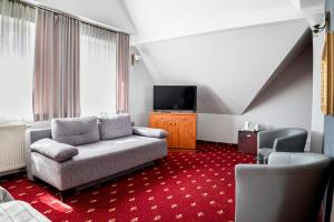 a living room with a couch and a tv at Villa Pascal in Gdańsk