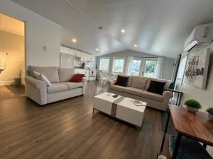 Sala de estar con 2 sofás y mesa en Crimson Crest Cottage, en Grand Bend