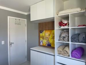 um quarto com prateleiras brancas e um armário em Casa em Condomínio Fechado na Praia do Francês em Marechal Deodoro
