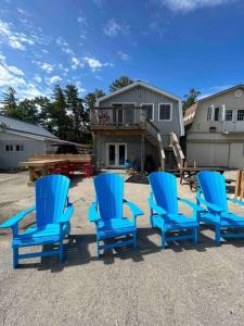 un grupo de sillas azules frente a una casa en Crimson Crest Cottage, en Grand Bend