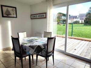 ein Esszimmer mit einem Tisch und Stühlen sowie einer Glasschiebetür in der Unterkunft Maison à 200m de la plage avec jardin clos sur l'ILE GRANDE - Réf 283 in Pleumeur-Bodou + 5 Fotos