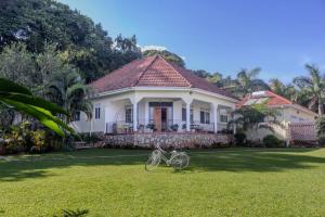 a white house with a bike parked in the yard at The Greenleaf Luxury BnB -Lubowa in Kampala