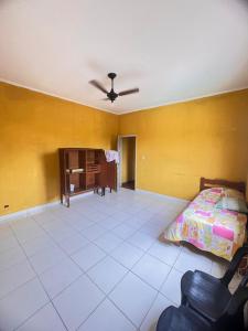 ein Schlafzimmer mit einem Bett und einem Klavier darin in der Unterkunft Casa para temporada baixada santista in Solemar