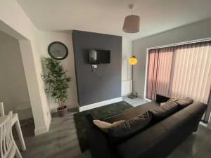a living room with a couch and a tv at Suite 1 - Large Private Room near City Centre in Liverpool