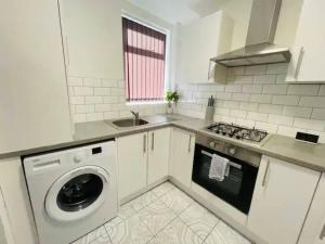 a kitchen with a washing machine and a sink at Suite 1 - Large Private Room near City Centre in Liverpool