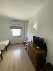 um quarto com uma cama e uma televisão numa cómoda em CASA DO PAÇO NOVO em Castelo de Vide