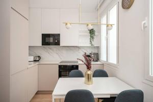 a white kitchen with a table and chairs at Luxury flat Mayor II in Madrid