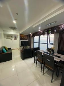 uma sala de estar com uma mesa e um sofá em SnugglePod Condotel - Grand Riviera Suites, US Embassy Manila, Roxas Blvd em Manila