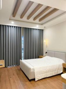 een slaapkamer met een groot wit bed en gordijnen bij Villa 3 Bedrooms Novaworld Phan Thiet in Bình Tú