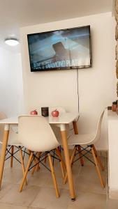 a table and two chairs and a tv on the wall at L’amazone in Sannois