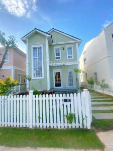 a white picket fence in front of a house at Villa 3 Bedrooms Novaworld Phan Thiet in Bình Tú
