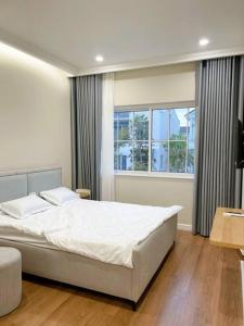 een slaapkamer met een groot bed en een raam bij Villa 3 Bedrooms Novaworld Phan Thiet in Bình Tú