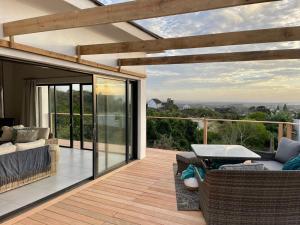 eine Terrasse mit einem Sofa und einem Tisch auf einer Terrasse in der Unterkunft Alchemy in St Francis Bay