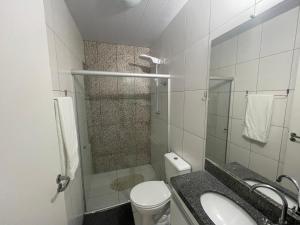 uma casa de banho com um chuveiro, um WC e um lavatório. em Casa em Condomínio Fechado na Praia do Francês em Marechal Deodoro