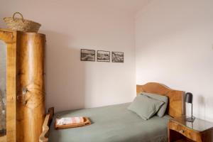 a bedroom with a bed with a wooden head board at Manas Slowliving - Sines in Sines