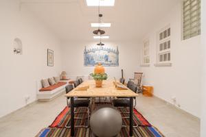 a dining room with a table and chairs and a couch at Manas Slowliving - Sines in Sines