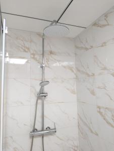a shower in a bathroom with white marble walls at MARINA ROOMS in Alicante
