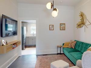 ein Wohnzimmer mit einem grünen Sofa und einer Küche in der Unterkunft Hiatus House in Savannah