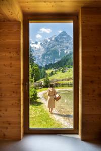 a woman walking through a door with a view at Hotel Bella Vista in Trafoi