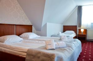 Dos camas en una habitación de hotel con toallas. en Villa Pascal, en Gdansk