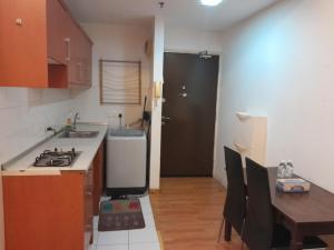 uma cozinha com um lavatório, uma mesa e um fogão em Maytower Homestay HJN em Kuala Lumpur