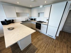 a kitchen with white cabinets and a counter top at Island Time in Sandown