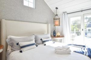 Un dormitorio con una cama blanca con almohadas y una ventana en Designed for vacation Easy 0 3 mi walk to Grey Neck Beach, en Harwich