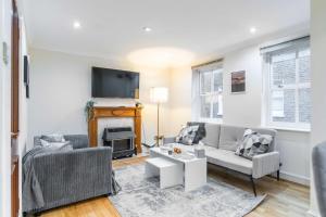 a living room with a couch and a tv at Livestay-Chic 3-Bed Mews Townhouse in St John's Wood in London