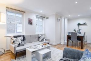 ロンドンにあるLivestay-Chic 3-Bed Mews Townhouse in St John's Woodのリビングルーム(ソファ、テーブル付)