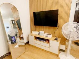 sala de estar con TV y ventilador en The Hideaway by K&C 1BR, Netflix,PS4, Wifi, en Imus