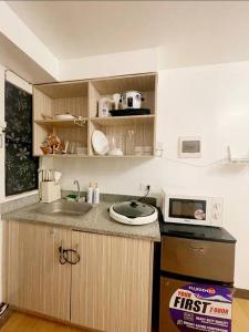 cocina con fregadero y microondas en The Hideaway by K&C 1BR, Netflix,PS4, Wifi, en Imus