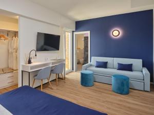 1 dormitorio con sofá, mesa y sillas en UNAWAY Imperial Beach Hotel en Marotta