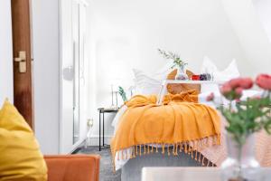 um quarto com uma cama com um cobertor laranja em Livestay-Chic 3-Bed Mews Townhouse in St John's Wood em Londres