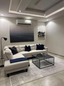 a living room with a couch and a tv at شقة فاخرة بتصميم حديث مع دخول ذاتي في الملقا - 11 in Riyadh