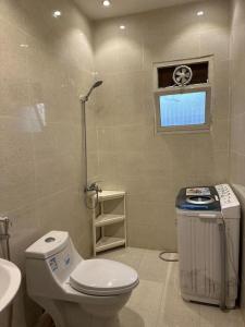 a bathroom with a toilet and a sink and a window at شقة فاخرة بتصميم حديث مع دخول ذاتي في الملقا - 11 in Riyadh