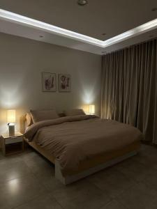 a bedroom with a large bed and two lamps at شقة فاخرة بتصميم حديث مع دخول ذاتي في الملقا - 11 in Riyadh