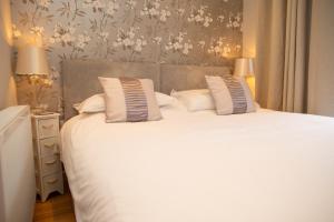 a bedroom with a large bed with white sheets and pillows at Vilureef Broad Haven in Broad Haven