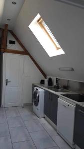 une cuisine avec un lave-linge et une fenêtre dans l'établissement JADE ET JENA, à Bazicourt
