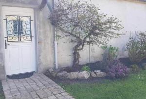 une porte blanche avec un arbre à côté d'une maison dans l'établissement JADE ET JENA, à Bazicourt